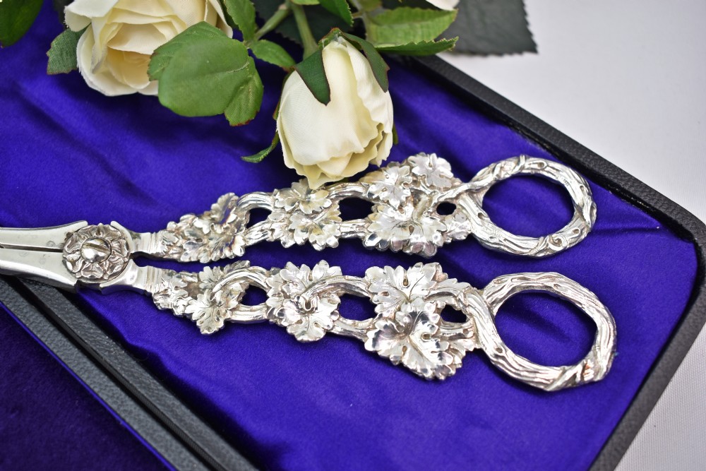 A pair of solid sterling silver grape scissors featuring heavily detailed cast grapevine handles with circular finger loops and tapered blades. View III
