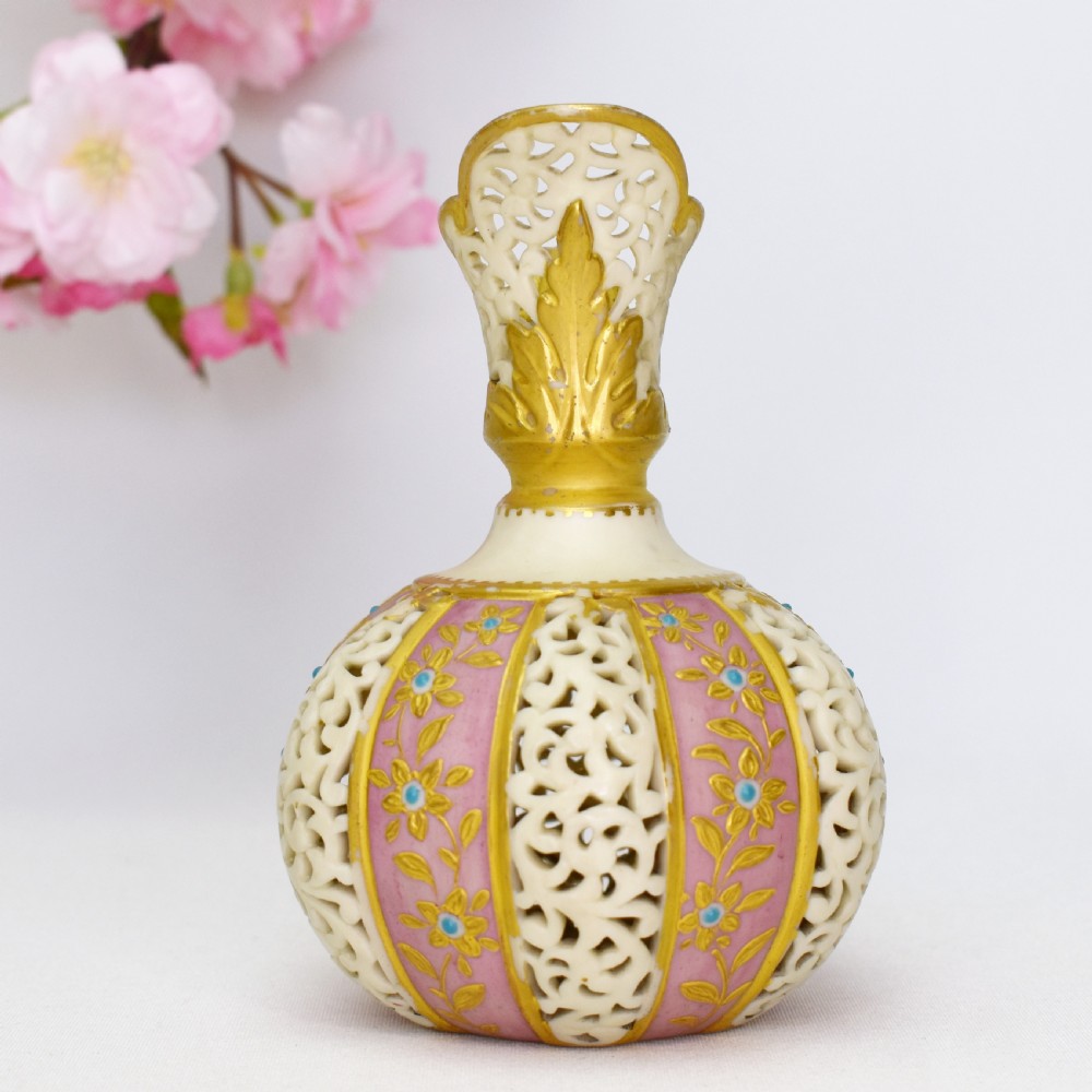 A late Victorian Grainger Worcester reticulated porcelain ewer featuring pink floral panels alternating with lattice pierced work and gilded accents. View II