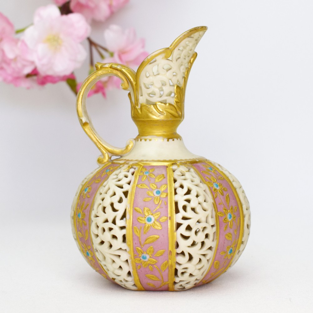 A late Victorian Grainger Worcester reticulated porcelain ewer featuring pink floral panels alternating with lattice pierced work and gilded accents. View III