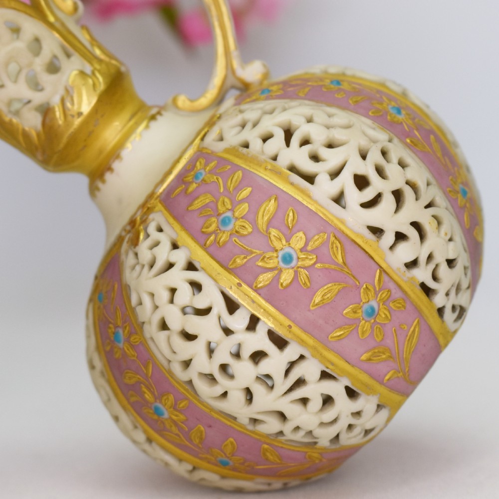 A late Victorian Grainger Worcester reticulated porcelain ewer featuring pink floral panels alternating with lattice pierced work and gilded accents. View VI