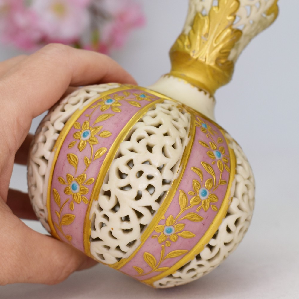A late Victorian Grainger Worcester reticulated porcelain ewer featuring pink floral panels alternating with lattice pierced work and gilded accents. View VII