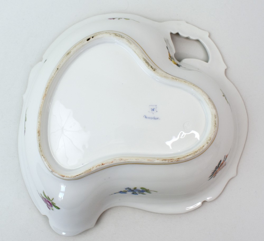 A white Rococo-style porcelain dish adorned with hand-painted floral sprays, a green inner rim, and a gilded scroll handle. View IX