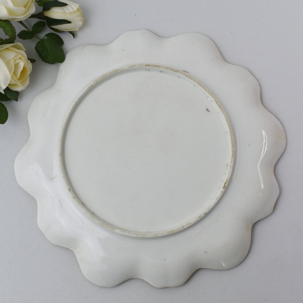 A circular Victorian porcelain cabinet plate featuring a hand-painted romantic pastoral scene enclosed by a lobed rim decorated with gold gilding. View VIII