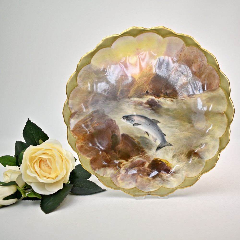 A set of four circular porcelain cabinet plates with scalloped gold rims, each featuring a central hand-painted scene of fish swimming in natural river settings. View III