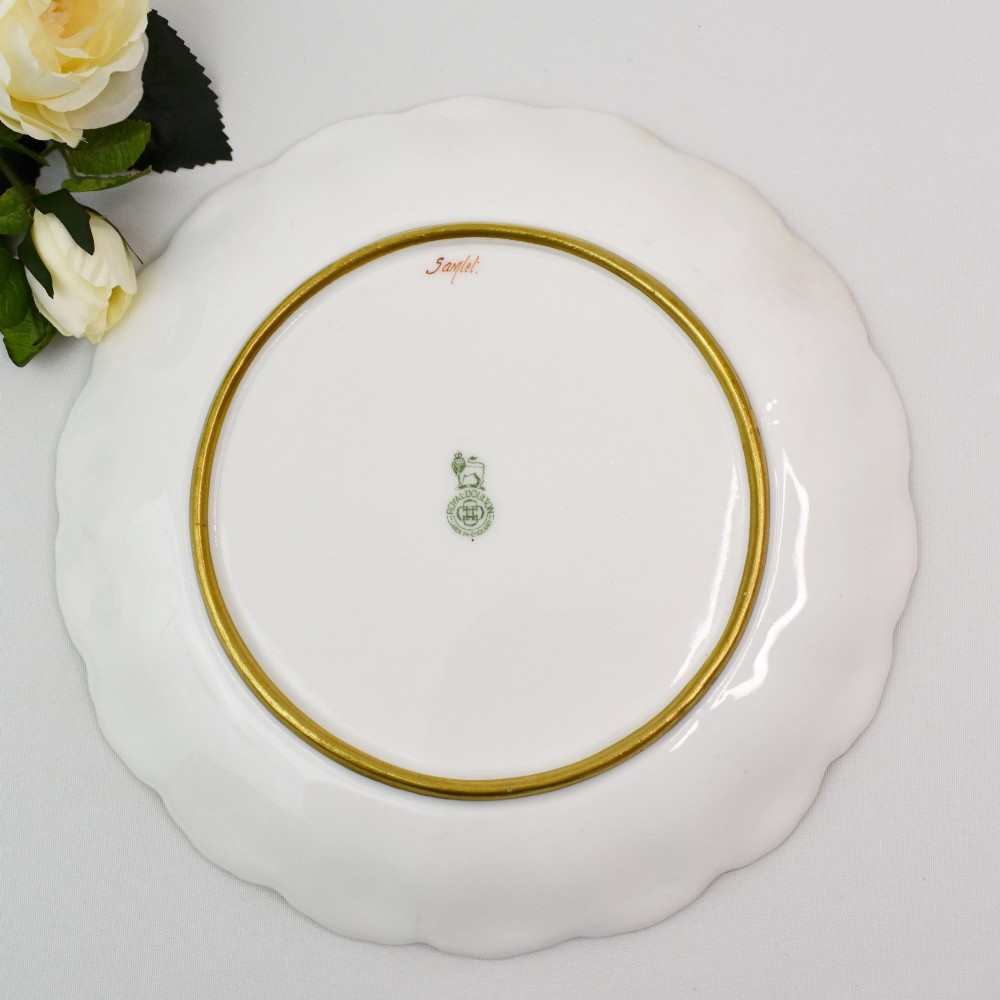 A set of four circular porcelain cabinet plates with scalloped gold rims, each featuring a central hand-painted scene of fish swimming in natural river settings. View XII