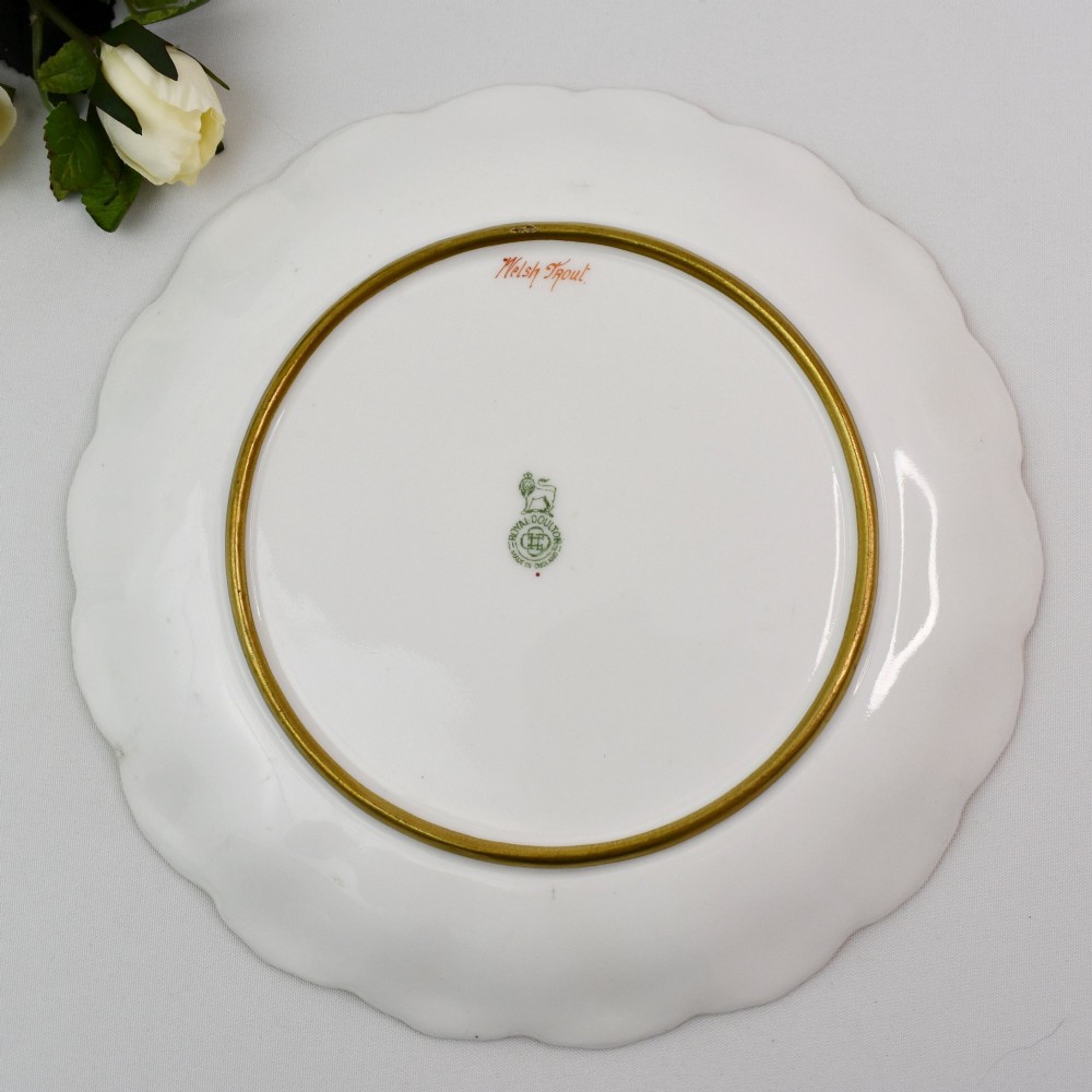 A set of four circular porcelain cabinet plates with scalloped gold rims, each featuring a central hand-painted scene of fish swimming in natural river settings. View XIV