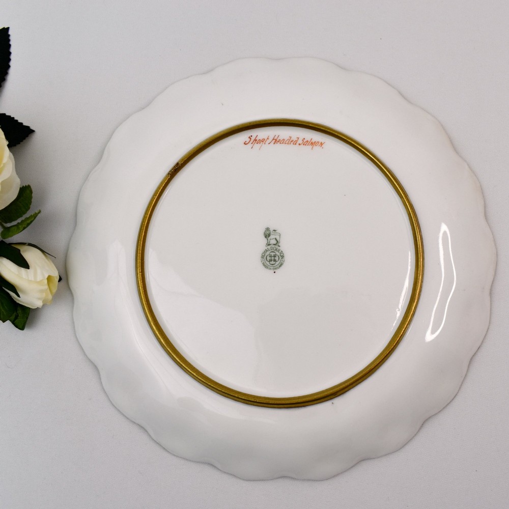 A set of four circular porcelain cabinet plates with scalloped gold rims, each featuring a central hand-painted scene of fish swimming in natural river settings. View XV