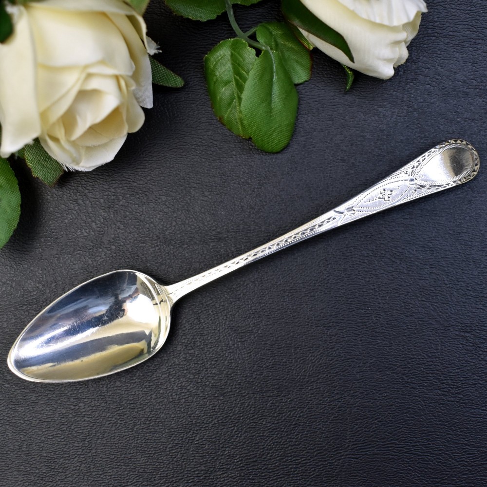 A set of six George III sterling silver teaspoons featuring bright-cut engraved stems and smooth oval bowls. View III