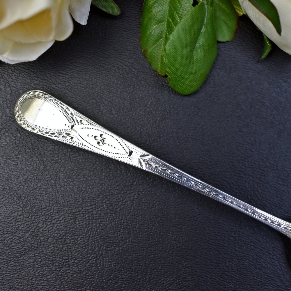 A set of six George III sterling silver teaspoons featuring bright-cut engraved stems and smooth oval bowls. View V