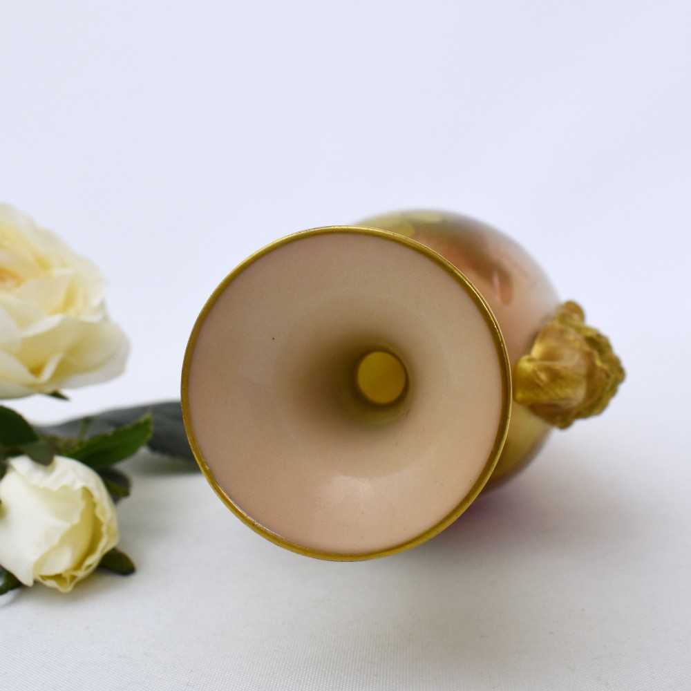 A hand-painted Royal Worcester porcelain vase decorated with pink and red roses, featuring gilded jester mask handles and a square base. View XI