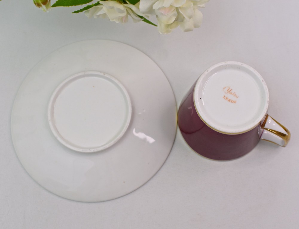 A Regency-era porcelain coffee cup and saucer featuring a deep claret ground, gilded borders, and a hand-painted panel depicting seashells. View VII