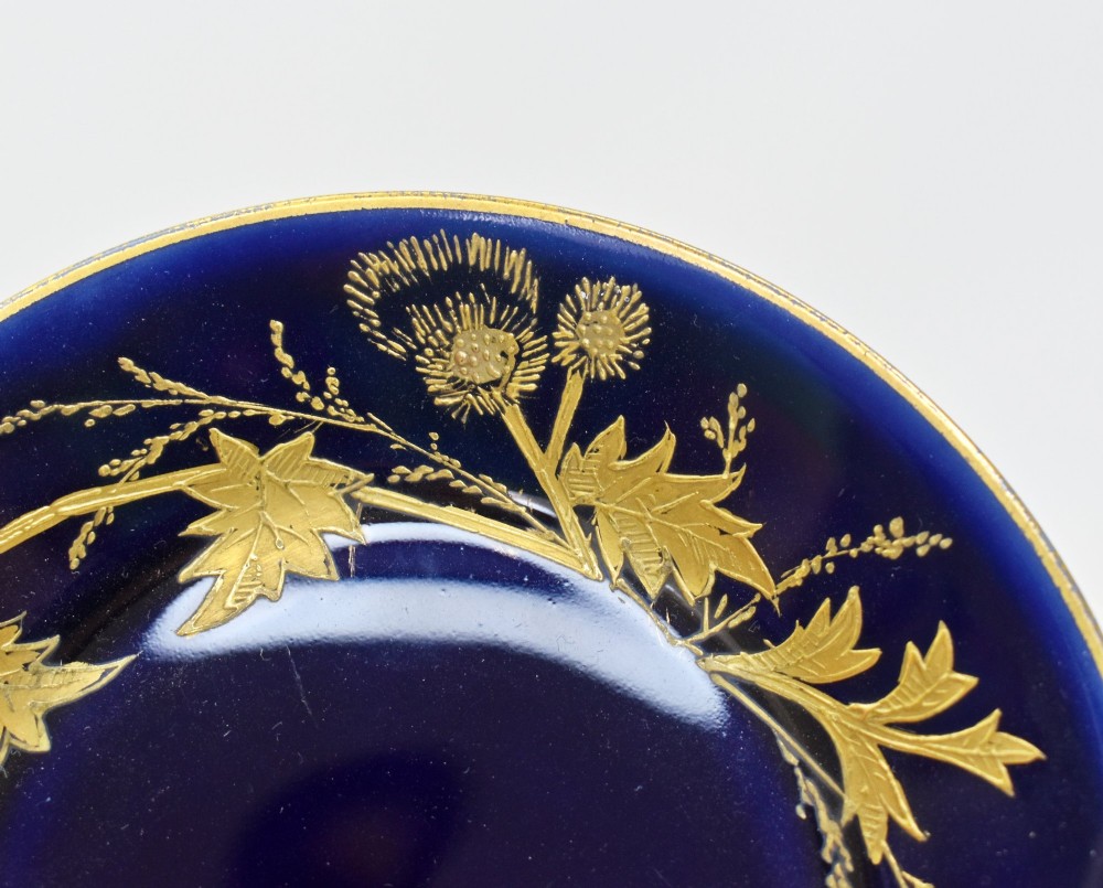 A French porcelain coffee cup and saucer in deep cobalt blue with raised gold gilded thistle motifs and a branch-formed gilt handle. View IV