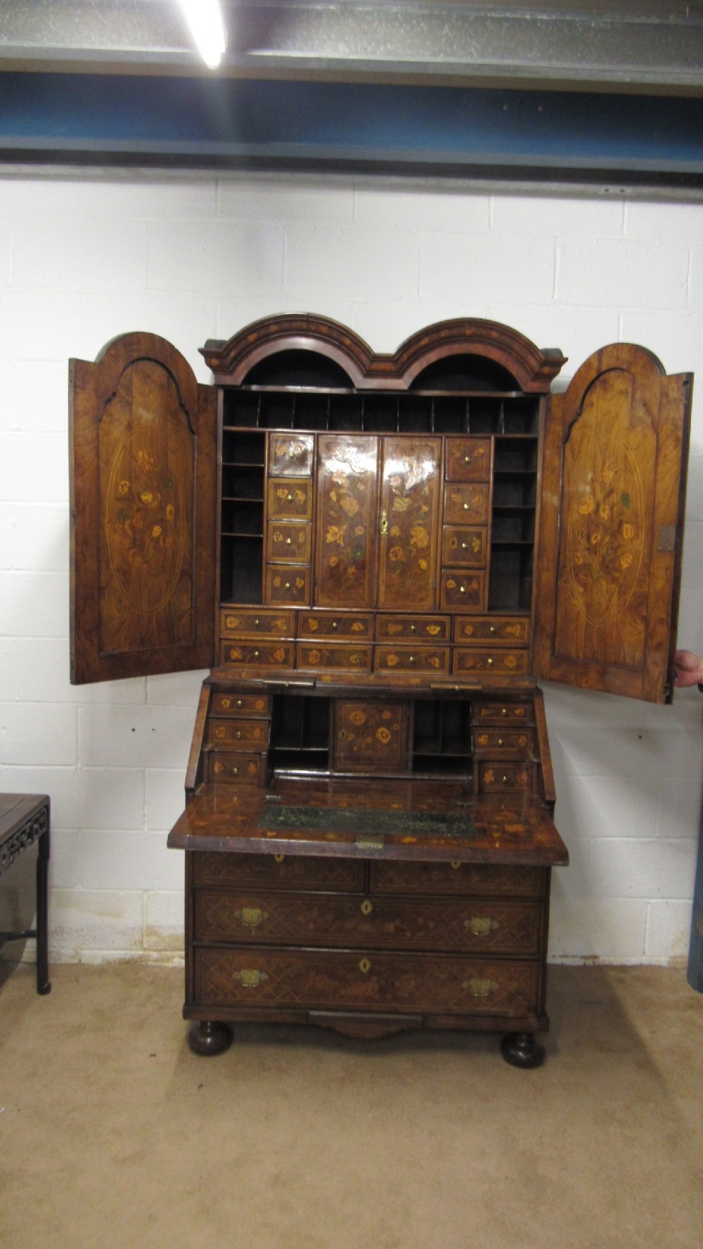 An 18th-century walnut bureau bookcase featuring intricate floral marquetry, a double-domed upper cabinet, a slant-front writing slope, and drawers raised on bun feet. View III