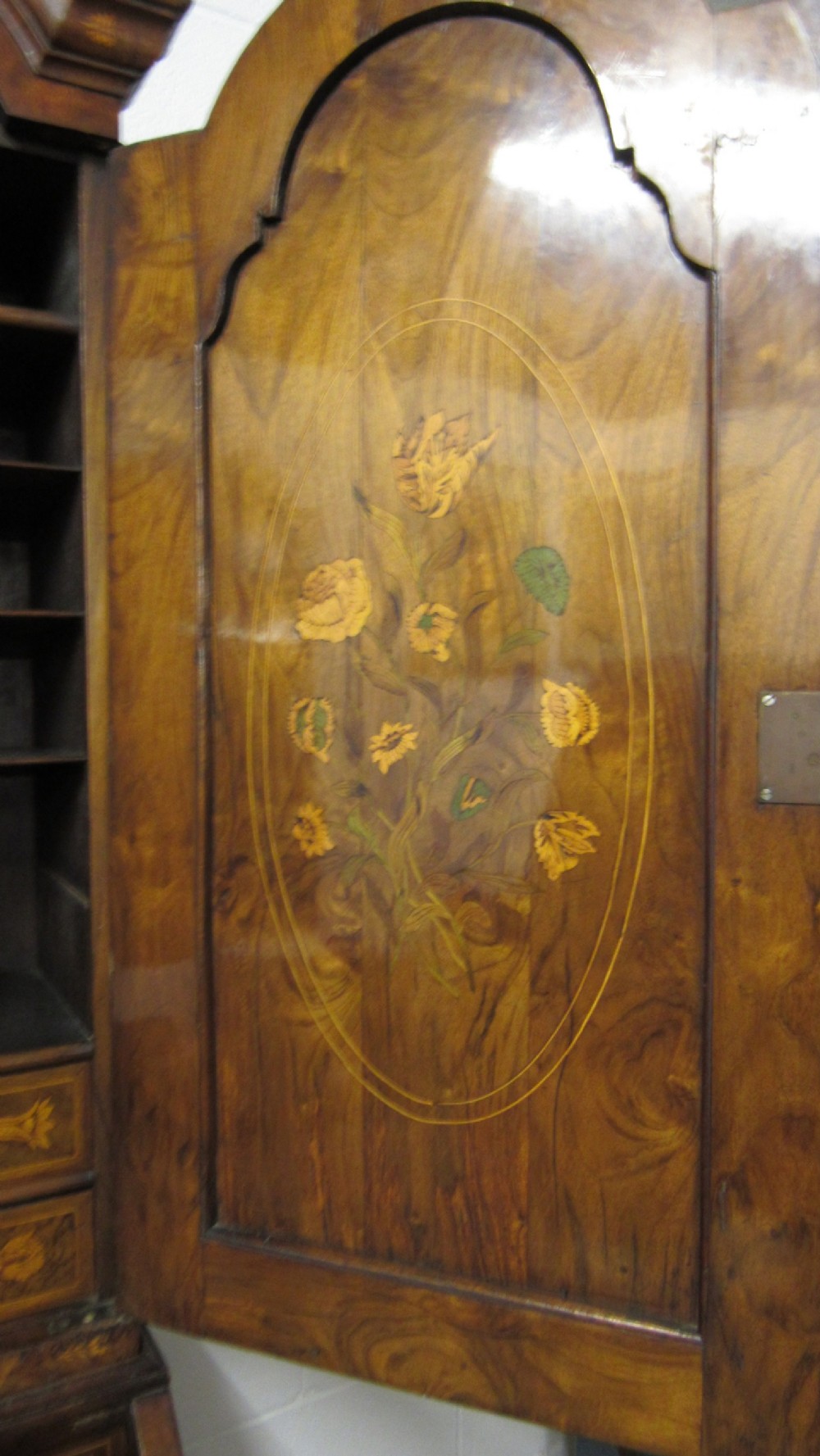 An 18th-century walnut bureau bookcase featuring intricate floral marquetry, a double-domed upper cabinet, a slant-front writing slope, and drawers raised on bun feet. View V