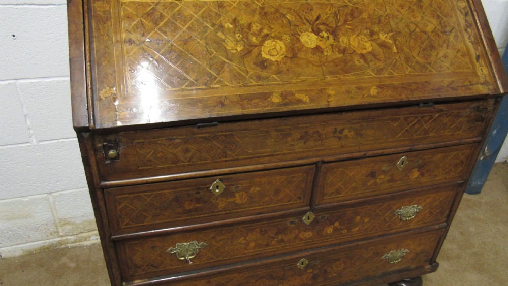 An 18th-century walnut bureau bookcase featuring intricate floral marquetry, a double-domed upper cabinet, a slant-front writing slope, and drawers raised on bun feet. View VIII
