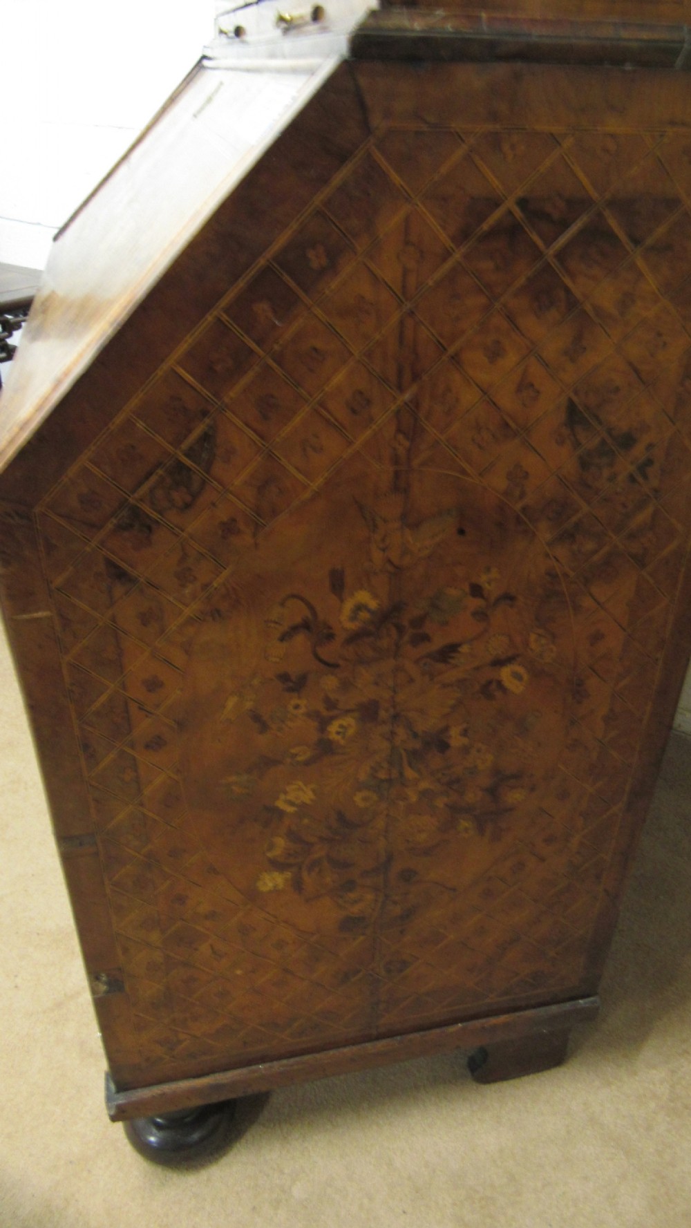 An 18th-century walnut bureau bookcase featuring intricate floral marquetry, a double-domed upper cabinet, a slant-front writing slope, and drawers raised on bun feet. View IX