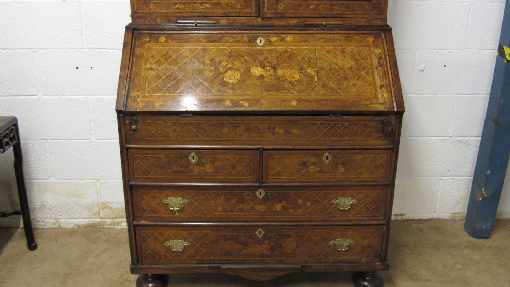 An 18th-century walnut bureau bookcase featuring intricate floral marquetry, a double-domed upper cabinet, a slant-front writing slope, and drawers raised on bun feet. View XI