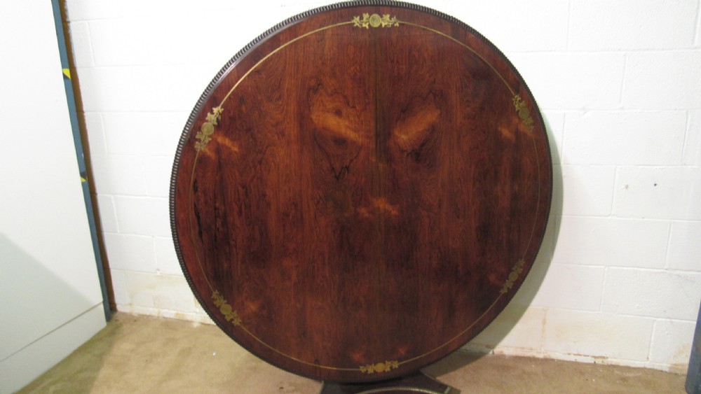 A circular Regency rosewood tilt-top loo table featuring brass marquetry inlay along the perimeter and a pedestal base. View II