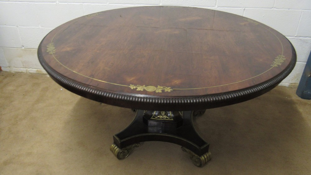 A circular Regency rosewood tilt-top loo table featuring brass marquetry inlay along the perimeter and a pedestal base. View IV