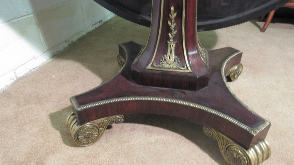A circular Regency rosewood tilt-top loo table featuring brass marquetry inlay along the perimeter and a pedestal base. View XI