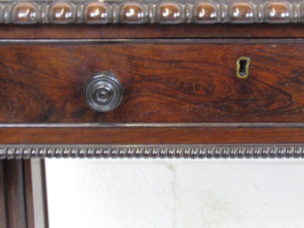 A 19th-century dark rosewood sofa table with two frieze drawers, drop-leaf side flaps, a turned central stretcher, and carved lion paw feet. View II