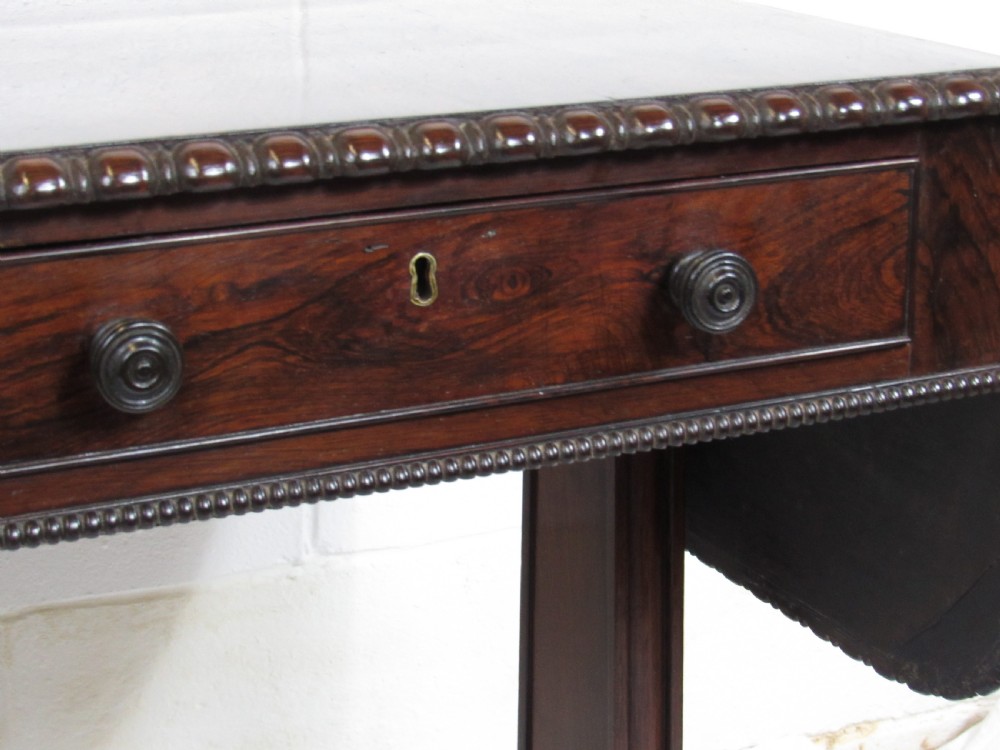 A 19th-century dark rosewood sofa table with two frieze drawers, drop-leaf side flaps, a turned central stretcher, and carved lion paw feet. View VIII