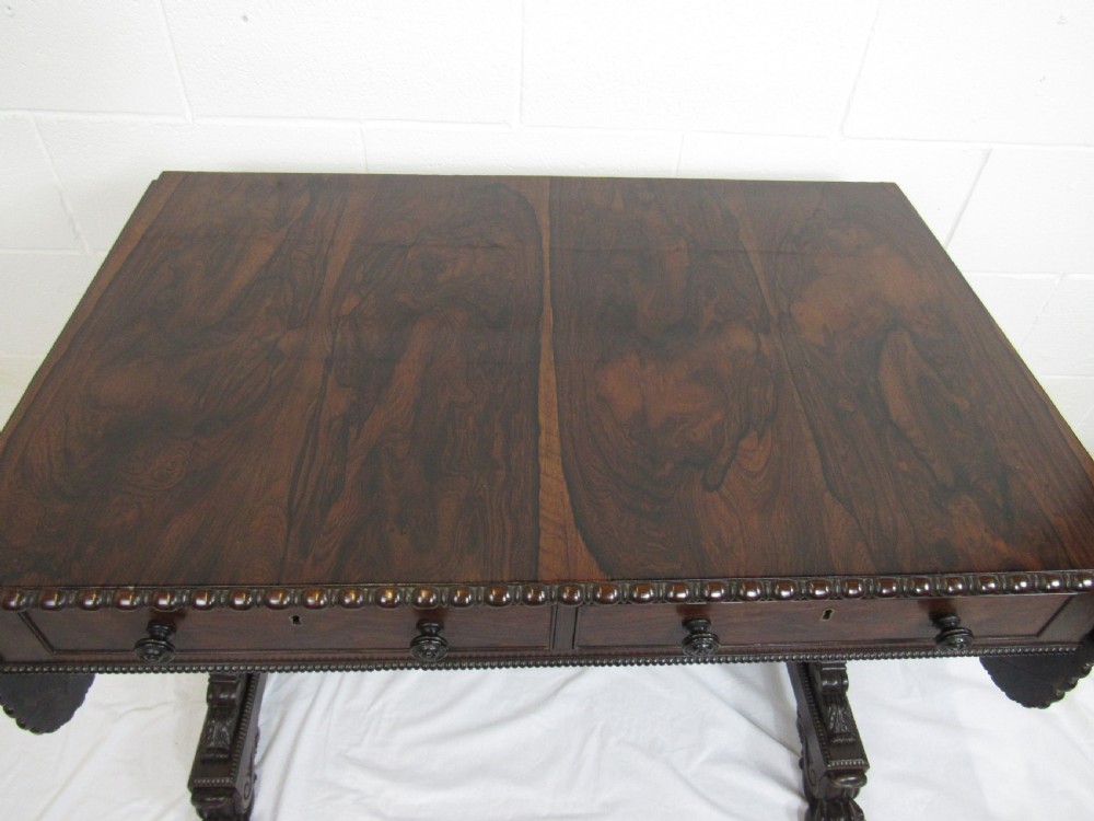 A 19th-century dark rosewood sofa table with two frieze drawers, drop-leaf side flaps, a turned central stretcher, and carved lion paw feet. View IX