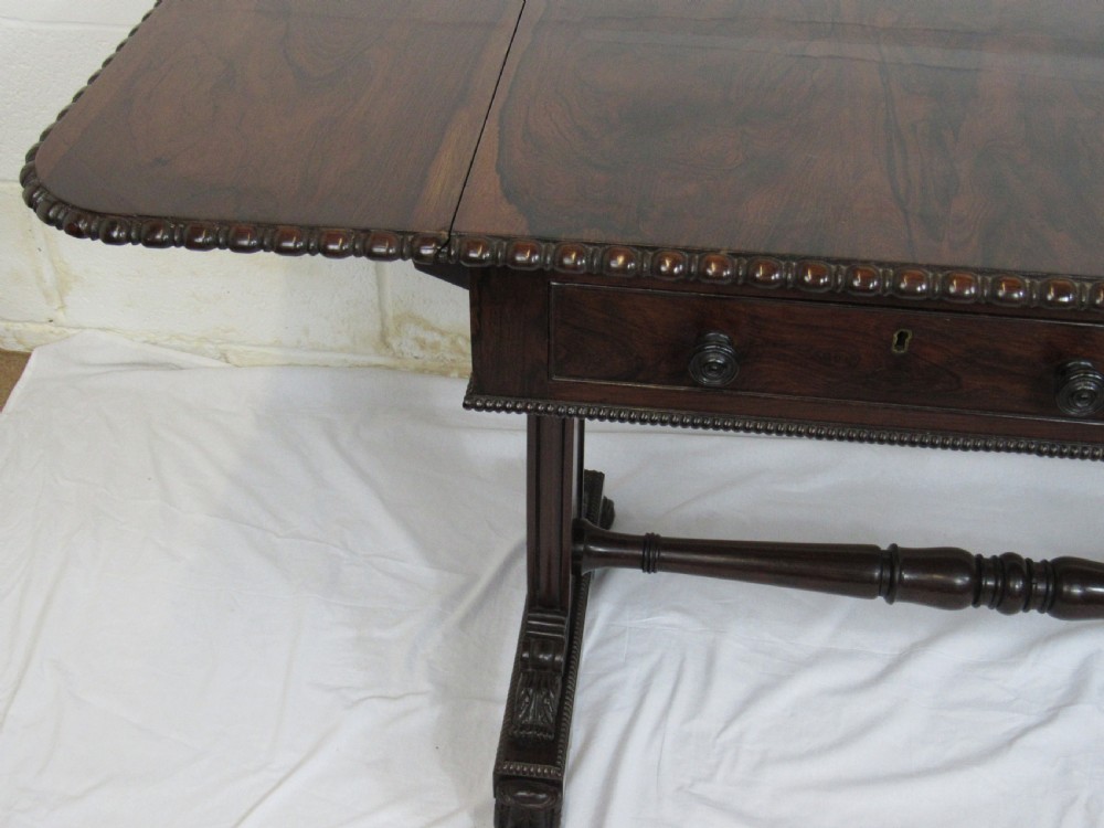 A 19th-century dark rosewood sofa table with two frieze drawers, drop-leaf side flaps, a turned central stretcher, and carved lion paw feet. View XII