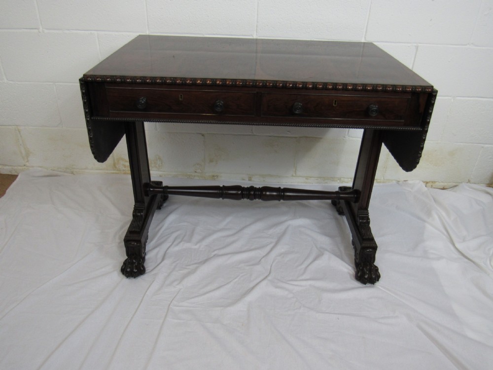 A 19th-century dark rosewood sofa table with two frieze drawers, drop-leaf side flaps, a turned central stretcher, and carved lion paw feet. View XV