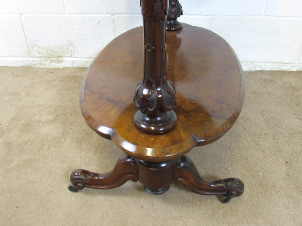 A Victorian burr walnut three-tier oval what-not etagere with turned columns, top finials, and carved feet on castors. View VII