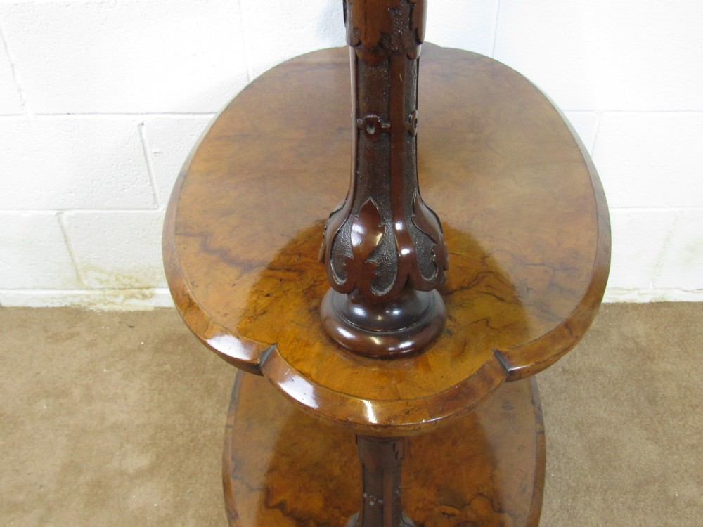 A Victorian burr walnut three-tier oval what-not etagere with turned columns, top finials, and carved feet on castors. View VIII
