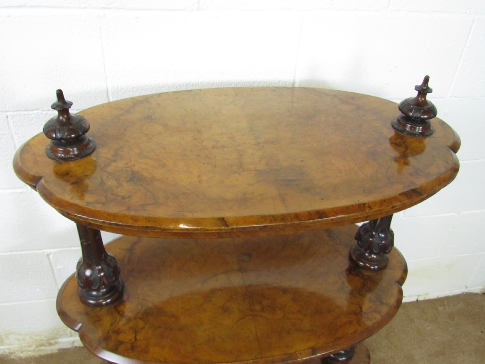 A Victorian burr walnut three-tier oval what-not etagere with turned columns, top finials, and carved feet on castors. View X