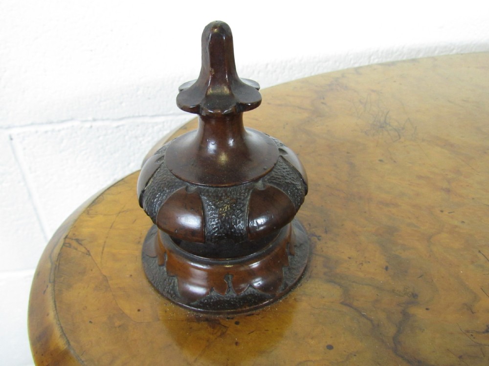 A Victorian burr walnut three-tier oval what-not etagere with turned columns, top finials, and carved feet on castors. View XII