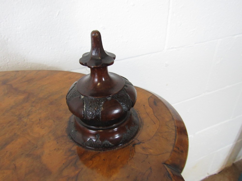 A Victorian burr walnut three-tier oval what-not etagere with turned columns, top finials, and carved feet on castors. View XIV