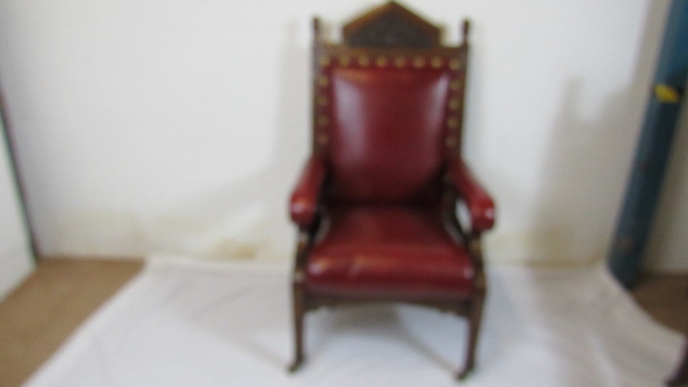 A pair of high-backed Gothic Revival armchairs crafted from carved dark wood and upholstered in deep red leather with brass stud detail. View VII