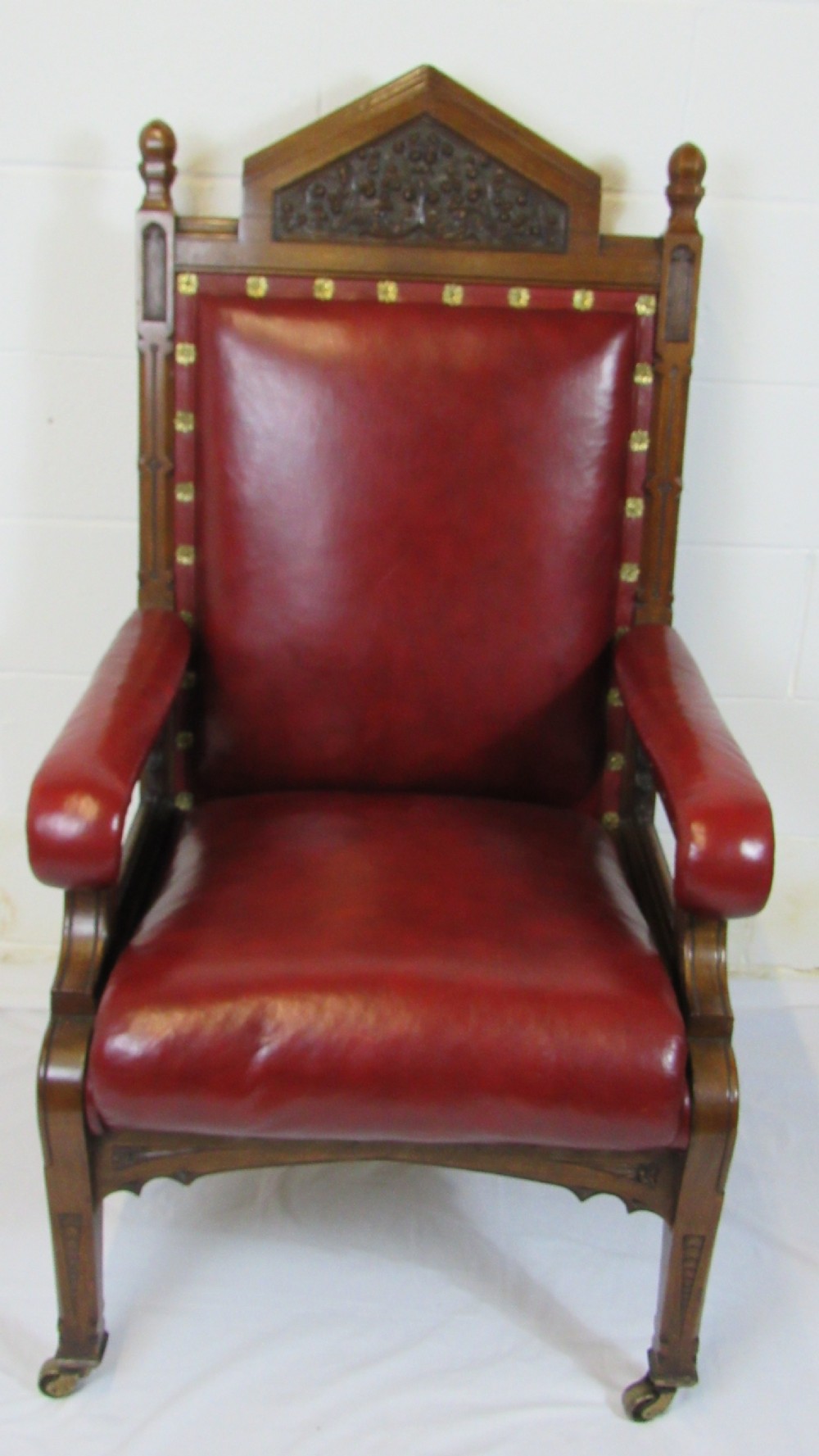A pair of high-backed Gothic Revival armchairs crafted from carved dark wood and upholstered in deep red leather with brass stud detail. View VIII