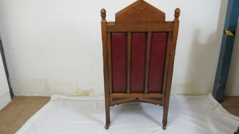 A pair of high-backed Gothic Revival armchairs crafted from carved dark wood and upholstered in deep red leather with brass stud detail. View XIV