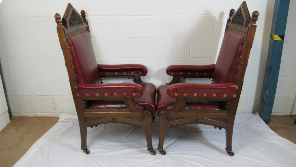 A pair of high-backed Gothic Revival armchairs crafted from carved dark wood and upholstered in deep red leather with brass stud detail. View XVII