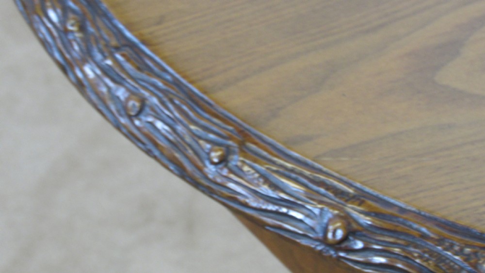 A circular 19th-century mahogany centre table with a carved rim, central pillar, and tri-form base with carved lion paw feet on brass castors. View III