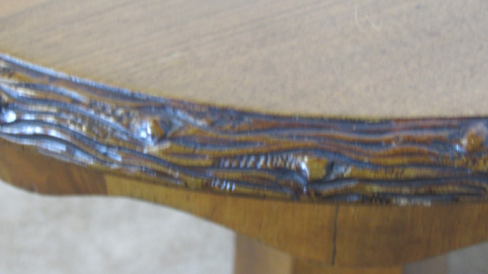 A circular 19th-century mahogany centre table with a carved rim, central pillar, and tri-form base with carved lion paw feet on brass castors. View V