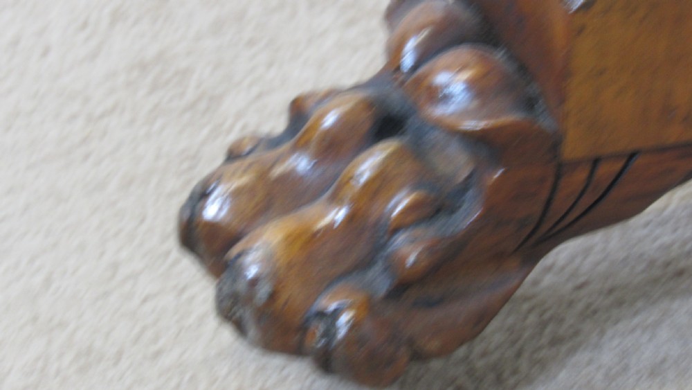 A circular 19th-century mahogany centre table with a carved rim, central pillar, and tri-form base with carved lion paw feet on brass castors. View VI