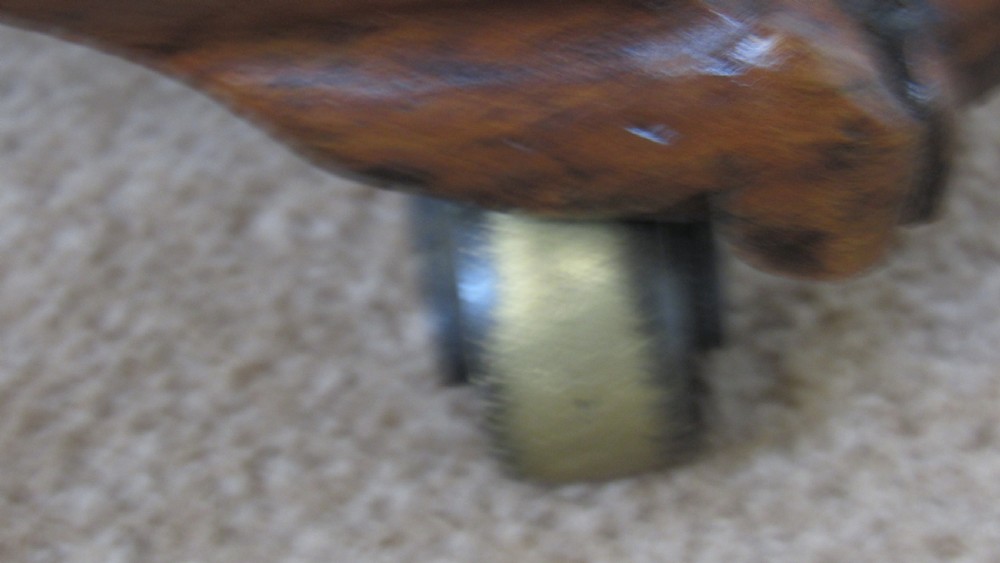 A circular 19th-century mahogany centre table with a carved rim, central pillar, and tri-form base with carved lion paw feet on brass castors. View IX