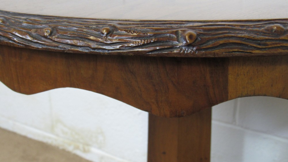 A circular 19th-century mahogany centre table with a carved rim, central pillar, and tri-form base with carved lion paw feet on brass castors. View X