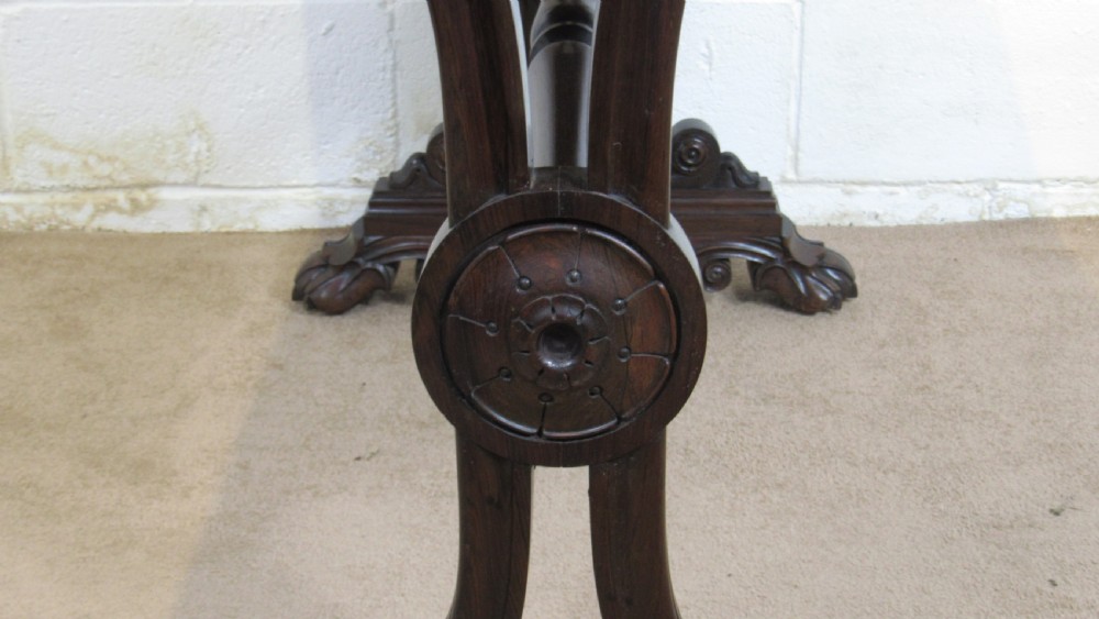 A dark rosewood library table featuring a polished rectangular top, frieze drawer, carved scroll trestle ends, a turned stretcher, and carved feet. View VI