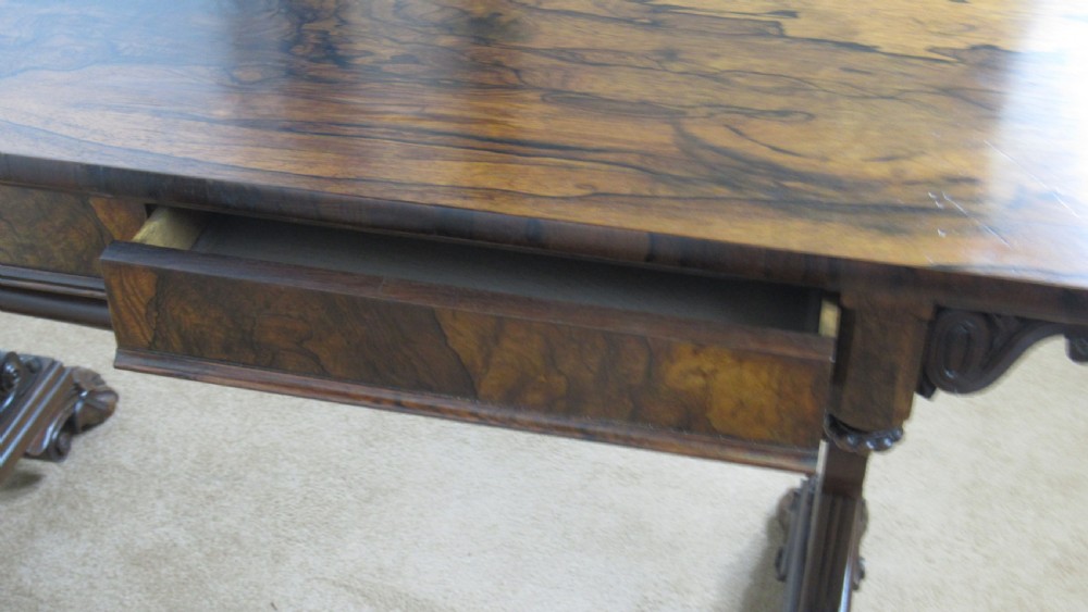 A dark rosewood library table featuring a polished rectangular top, frieze drawer, carved scroll trestle ends, a turned stretcher, and carved feet. View XIII