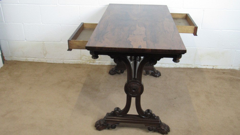 A dark rosewood library table featuring a polished rectangular top, frieze drawer, carved scroll trestle ends, a turned stretcher, and carved feet. View XIV