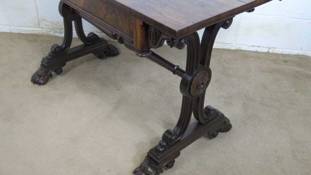 A dark rosewood library table featuring a polished rectangular top, frieze drawer, carved scroll trestle ends, a turned stretcher, and carved feet. View XVII