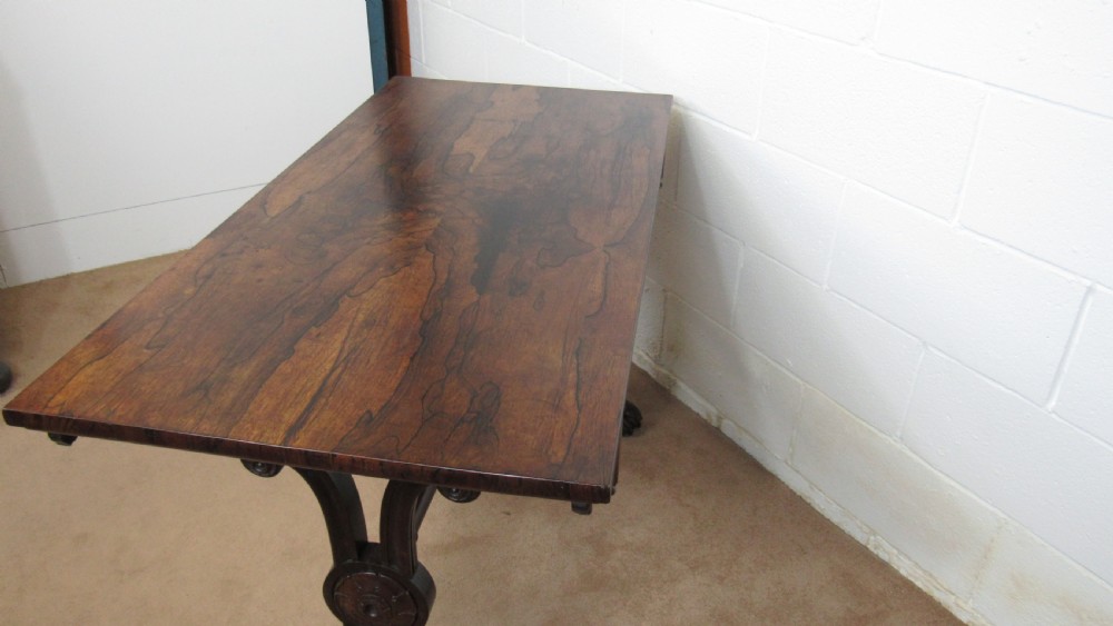 A dark rosewood library table featuring a polished rectangular top, frieze drawer, carved scroll trestle ends, a turned stretcher, and carved feet. View XVIII