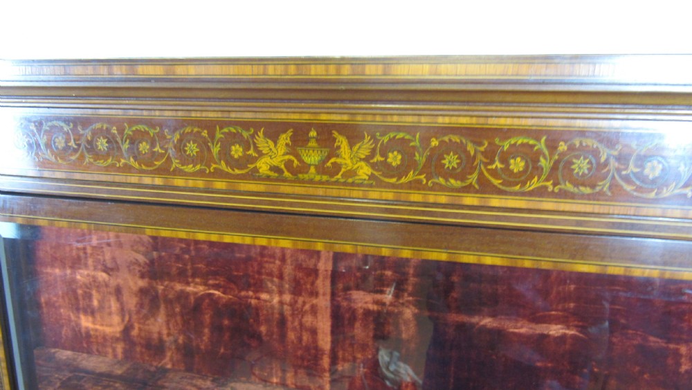 An Edwardian fiddleback mahogany display cabinet featuring glazed doors, detailed floral marquetry inlay on the lower panels, and square tapered legs. View II