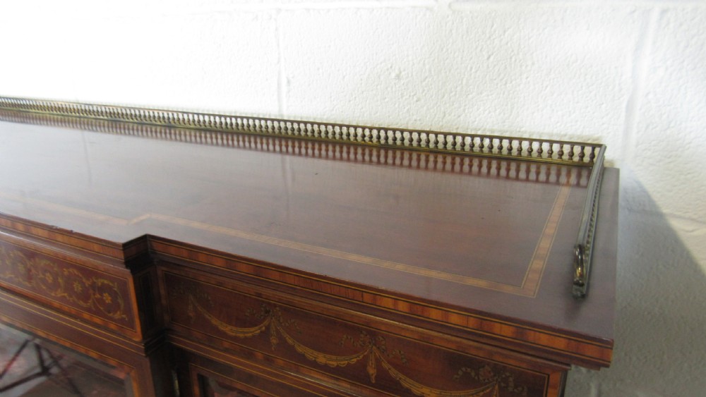 An Edwardian fiddleback mahogany display cabinet featuring glazed doors, detailed floral marquetry inlay on the lower panels, and square tapered legs. View IV